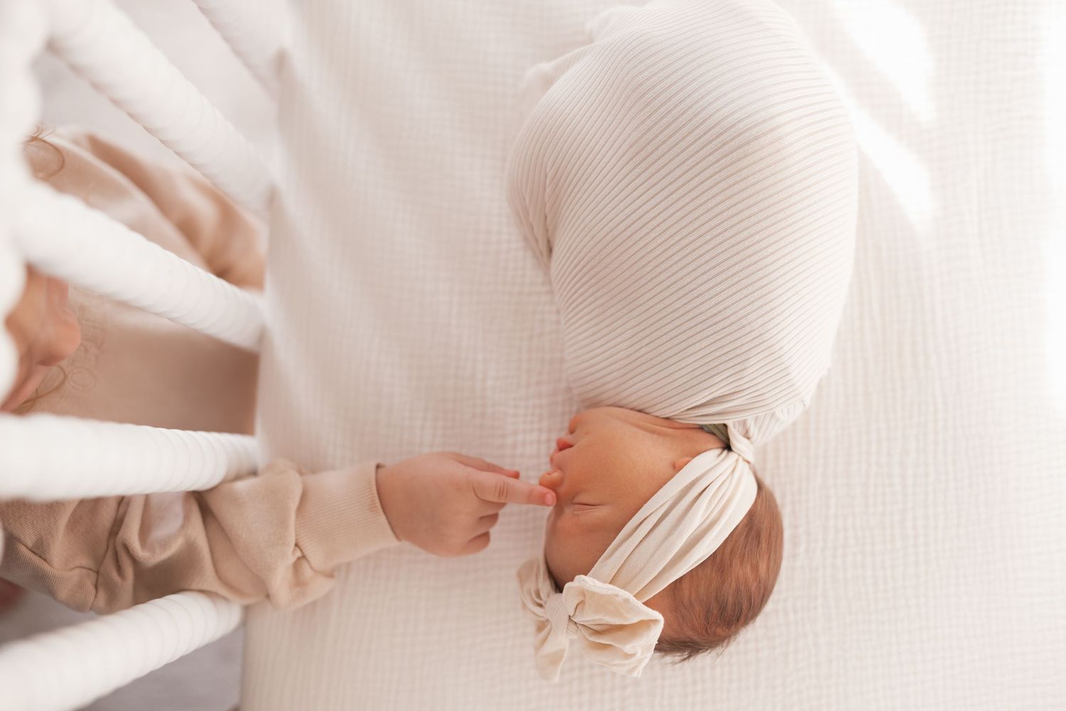 Intimate newborn photo with soft white fabric draping.