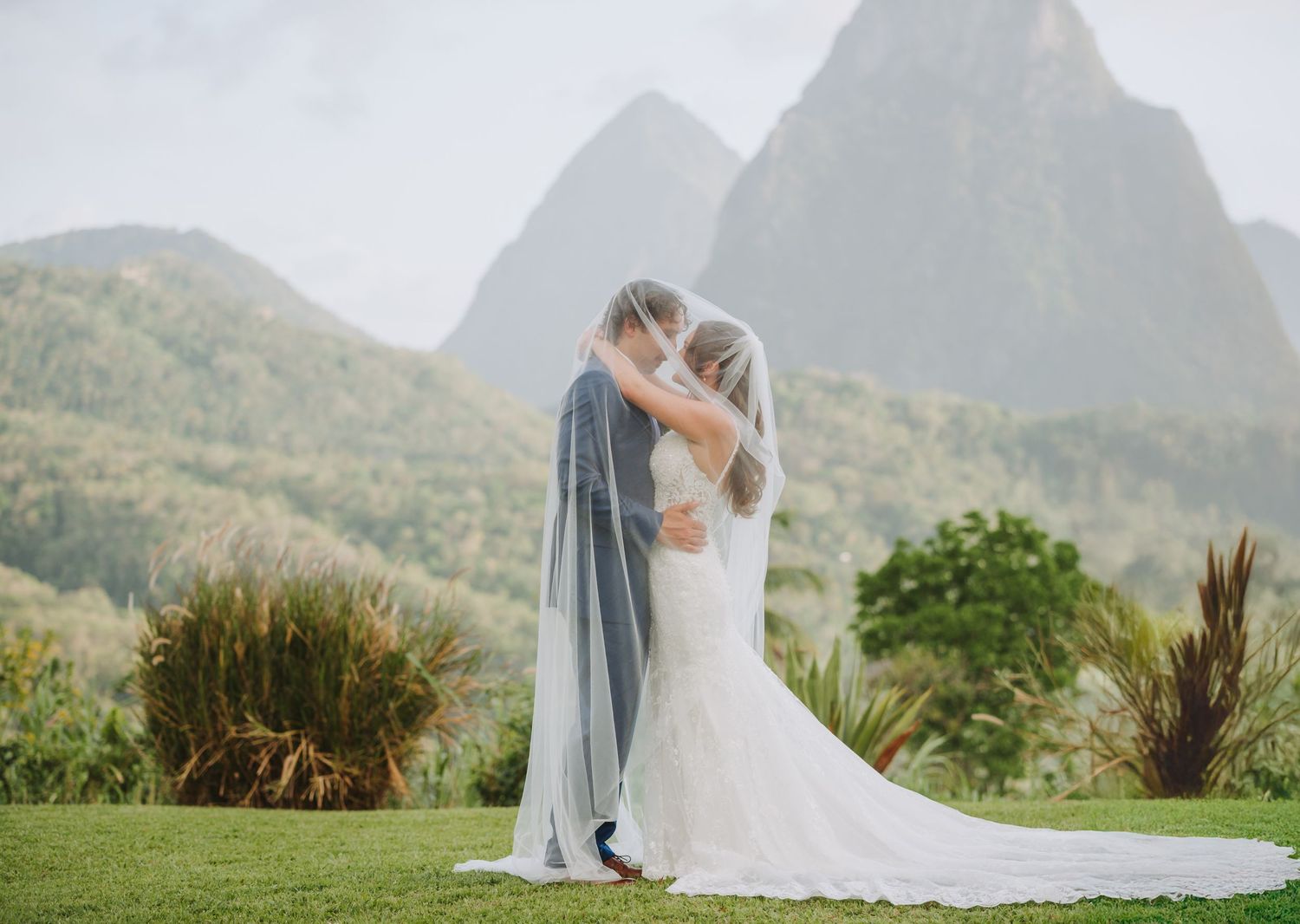 St Lucia wedding photographer captures married couple pose in front of La Haut, Piton view in their destination wedding in St Lucia
