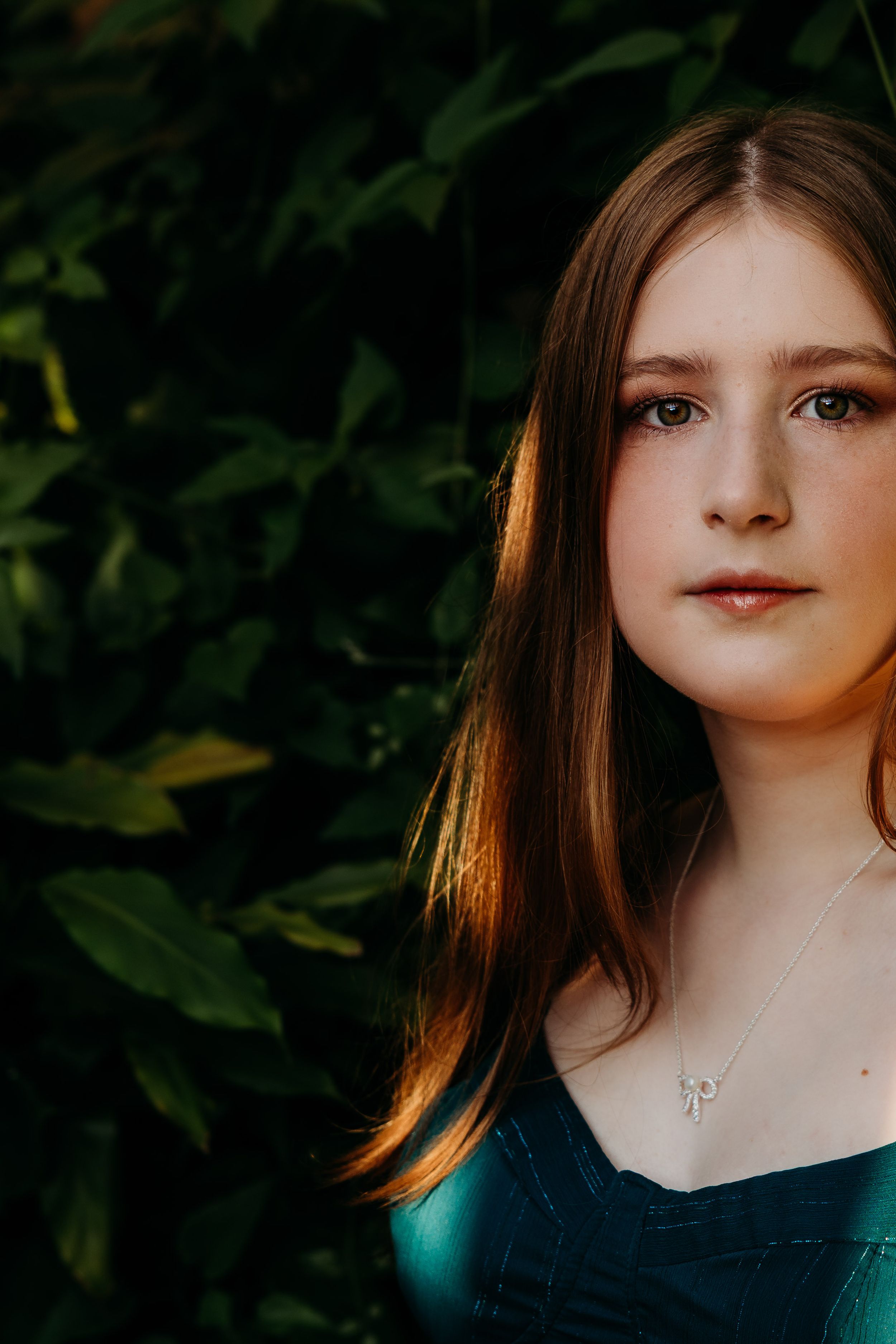 Portrait series showing closeup cropped views of someone with brown hair wearing a teal top against a dark green background.