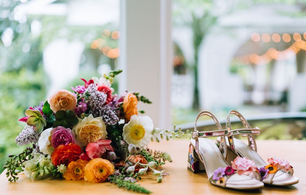 Delicate floral arrangements with peach and orange blooms decorating a wedding table.