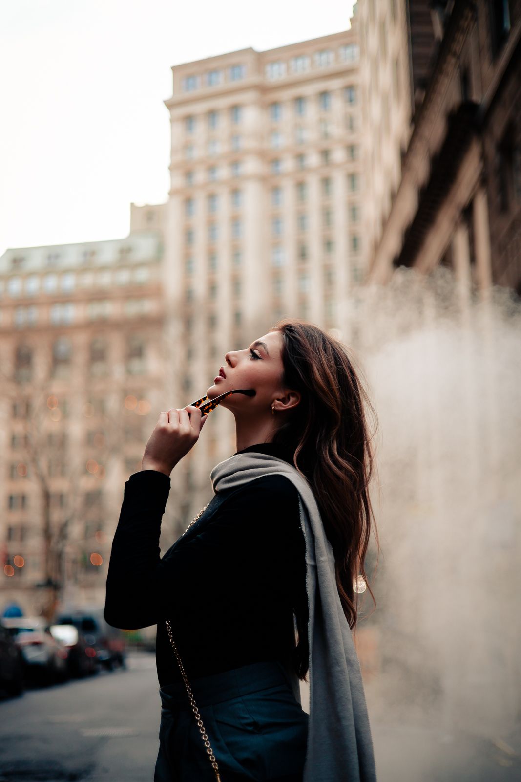 Urban Vogue-inspired editorial, woman in sleek coat between skyscrapers, West Palm Beach fashion photography by Mannyportraits