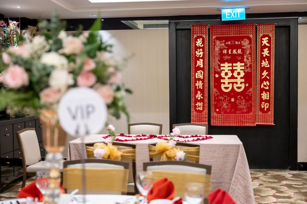Traditional Chinese wedding banquet setup with red double happiness banner and elegant table settings in a restaurant.
