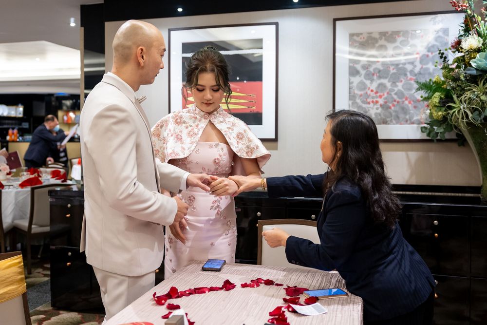 Guests mingle and interact in a formal indoor setting with a piano visible in the background.