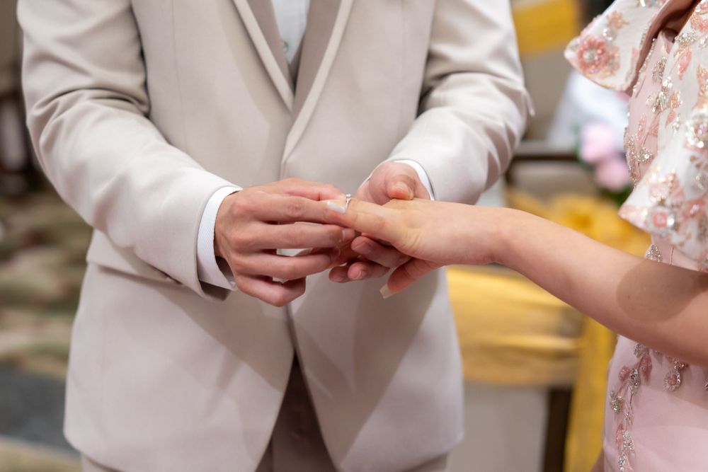 Close-up of hands exchanging rings during a traditional wedding ceremony.