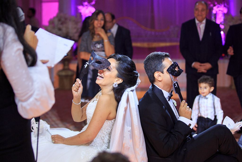 Wedding reception dance floor filled with guests celebrating under purple lighting.