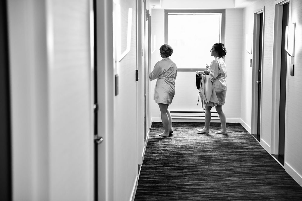 Healthcare staff walk down a bright hospital hallway with white walls and natural light streaming through windows.