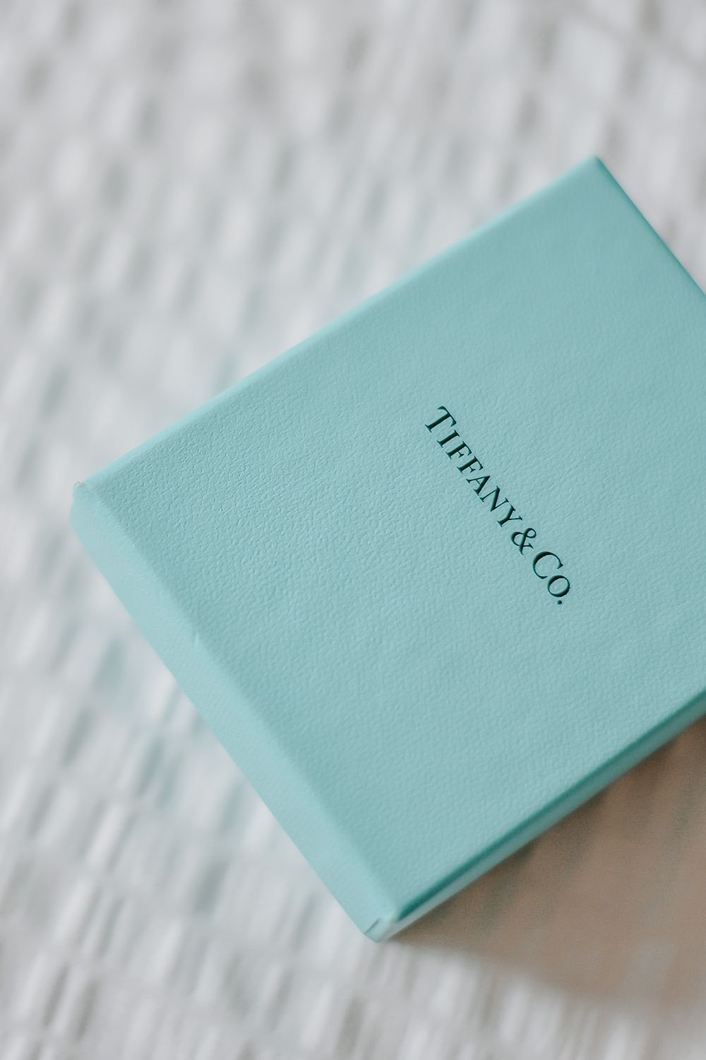 A series of Tiffany & Co. light blue jewelry boxes arranged in a cascading diagonal line against a white background.
