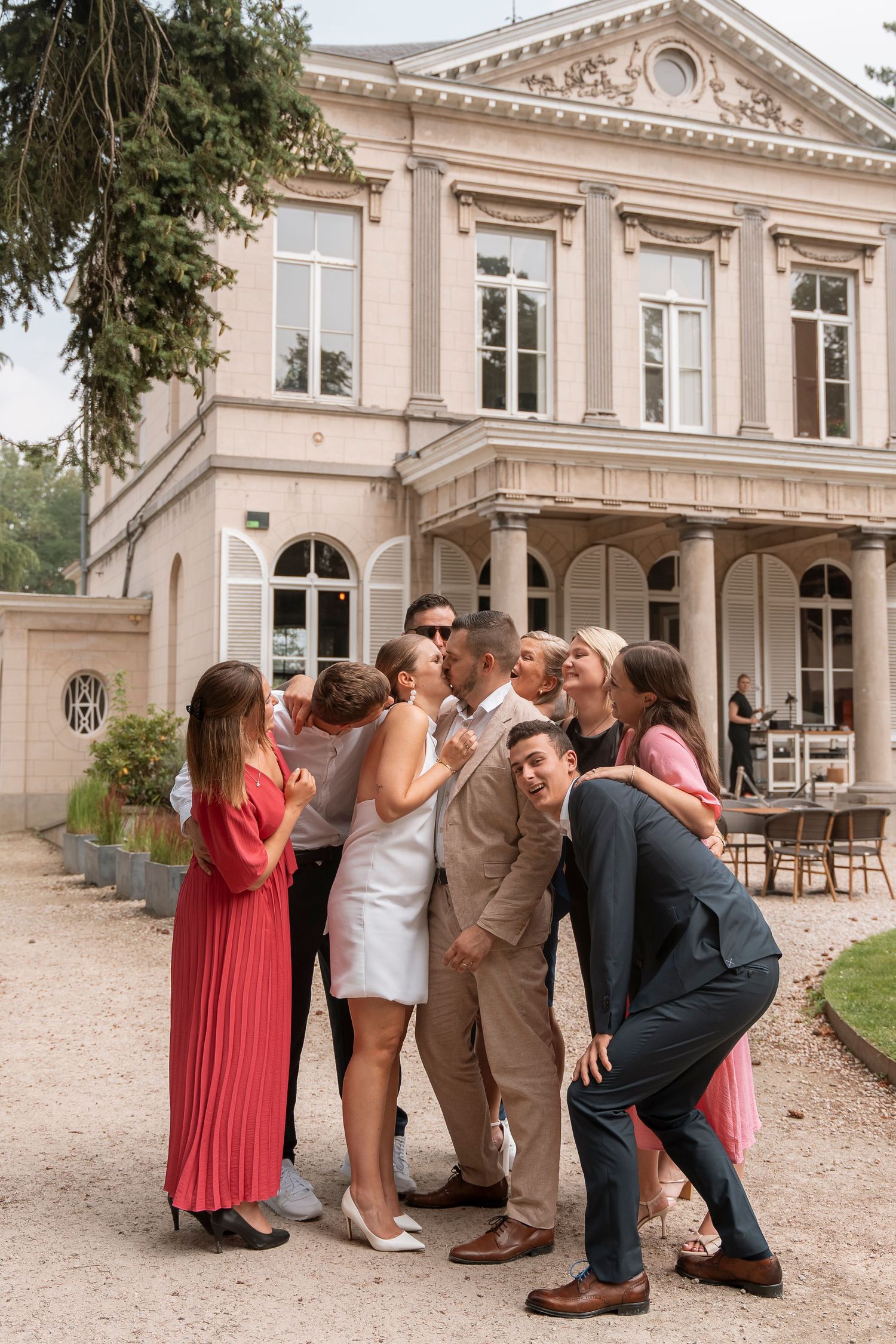 A festive group poses together for a fun photo outside a classical building.