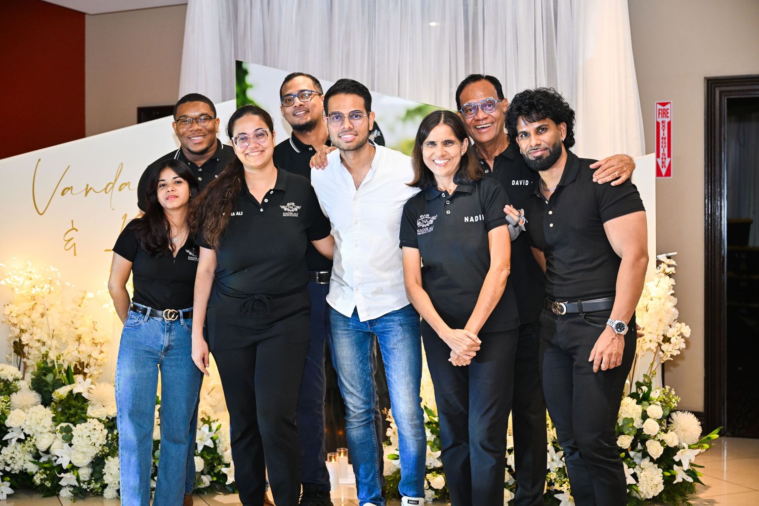 Group photo of event staff members in matching uniforms posing together.