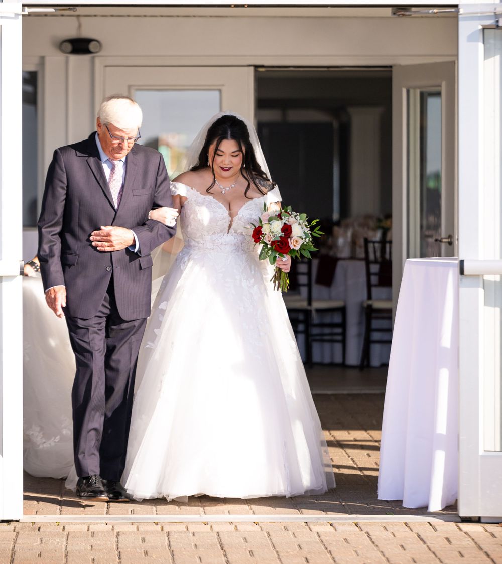 Elegant wedding processional sequence with attendants walking along a white columned porch entrance.