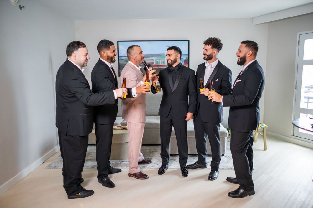 Wedding party members socializing and taking photos together in modern indoor setting.