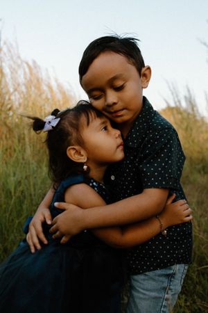 Siblings embrace during the sunset, on the floodplains in rural Darwin, NT