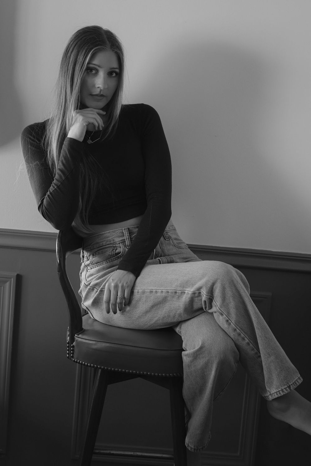 Artistic black and white portrait series showing relaxed poses on a chair.