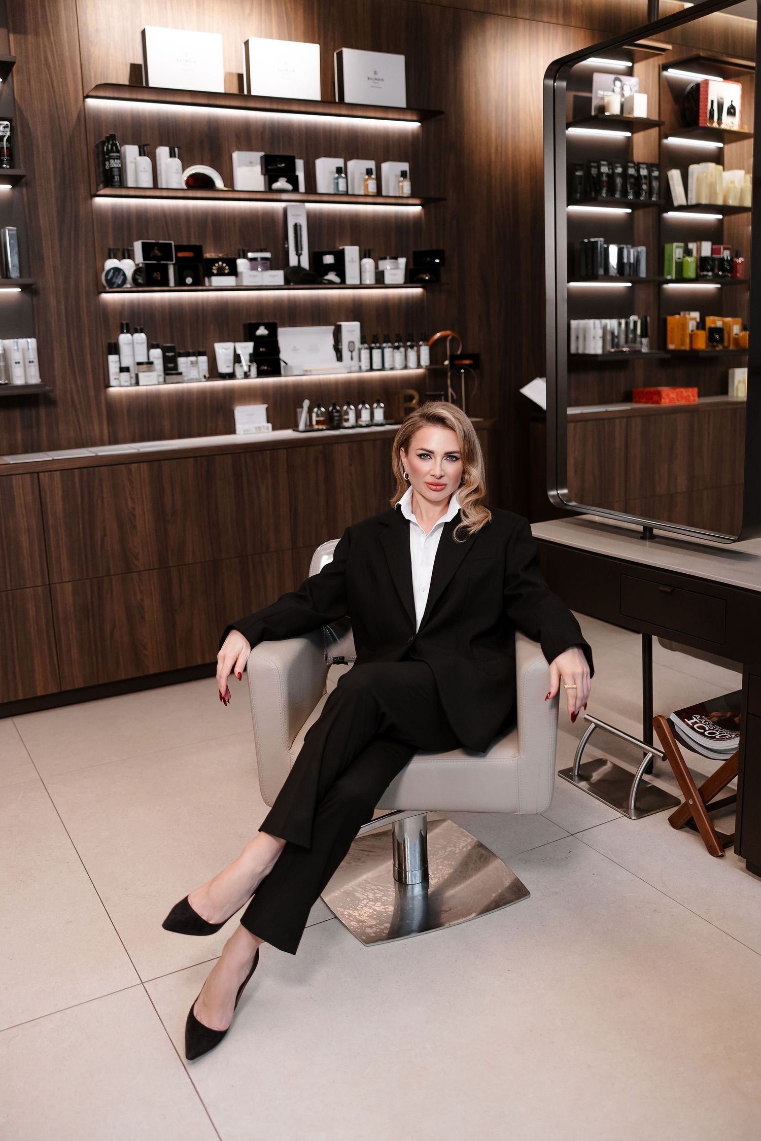 Professional portrait in retail space with wooden shelving displaying beauty products.