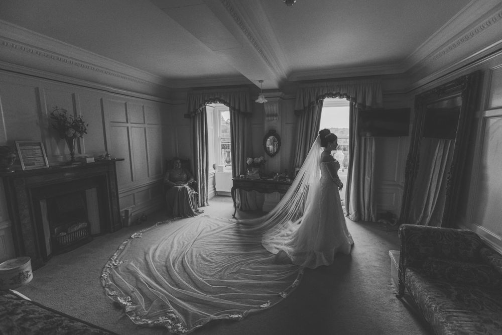 Bride walking down elegant staircase inside historic venue – wedding photographer Luis Gomes in London