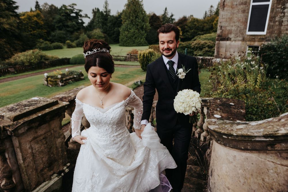 Bride and groom walking through countryside garden – wedding photographer Luis Gomes in Cambridgeshire