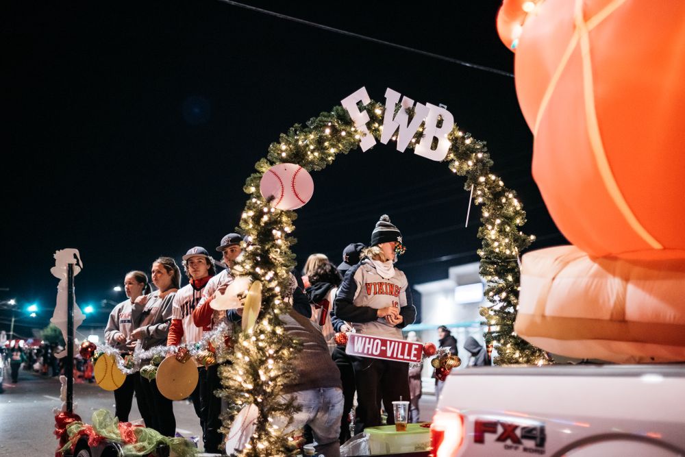 Large illuminated orange inflatable decoration glows against night sky at holiday event.