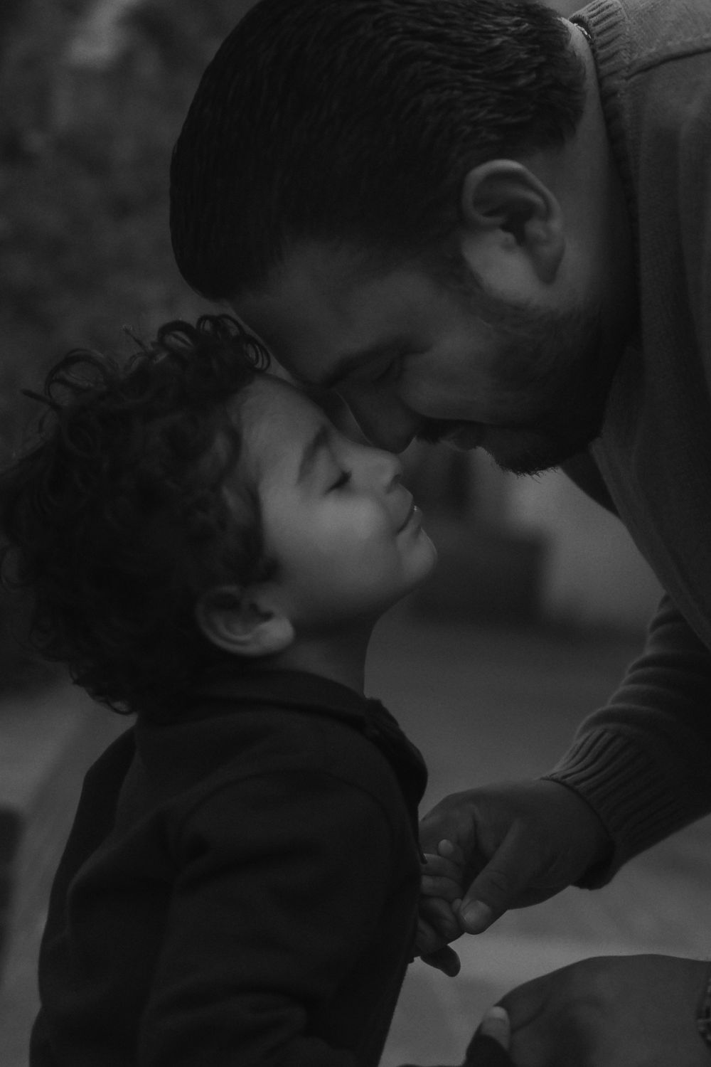 Black and white photo of parent and child sharing an intimate bonding moment.