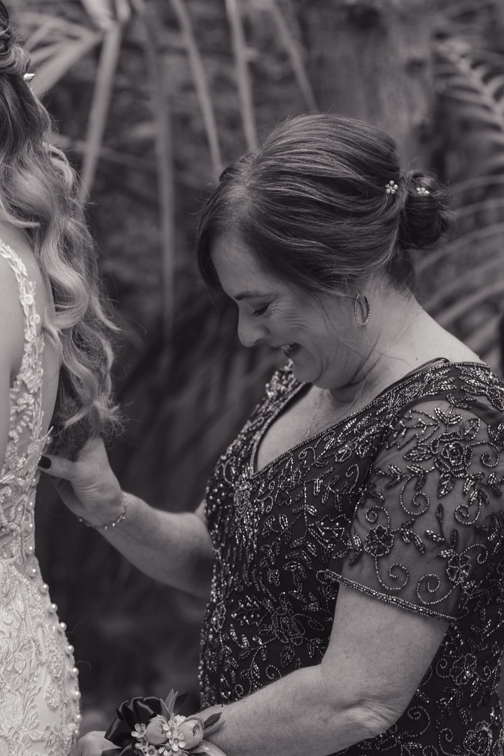 A touching black and white moment with a guest admiring a beautiful wedding dress at a celebration.