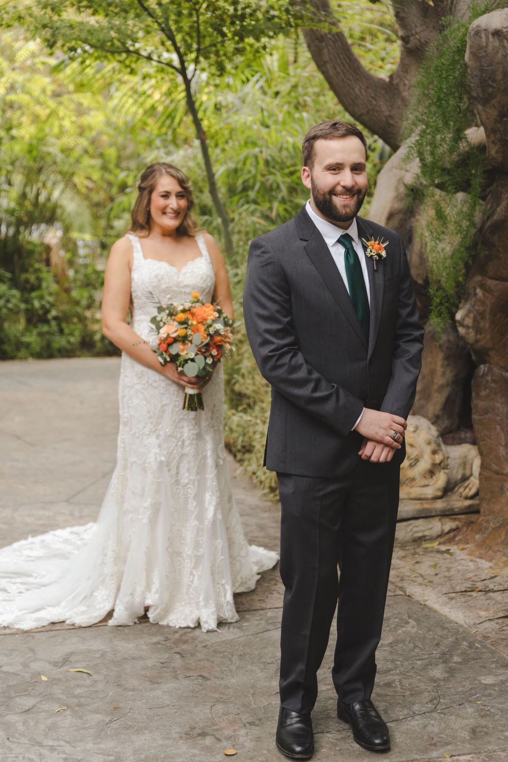 A first look wedding photo in a garden pathway featuring traditional formal attire.