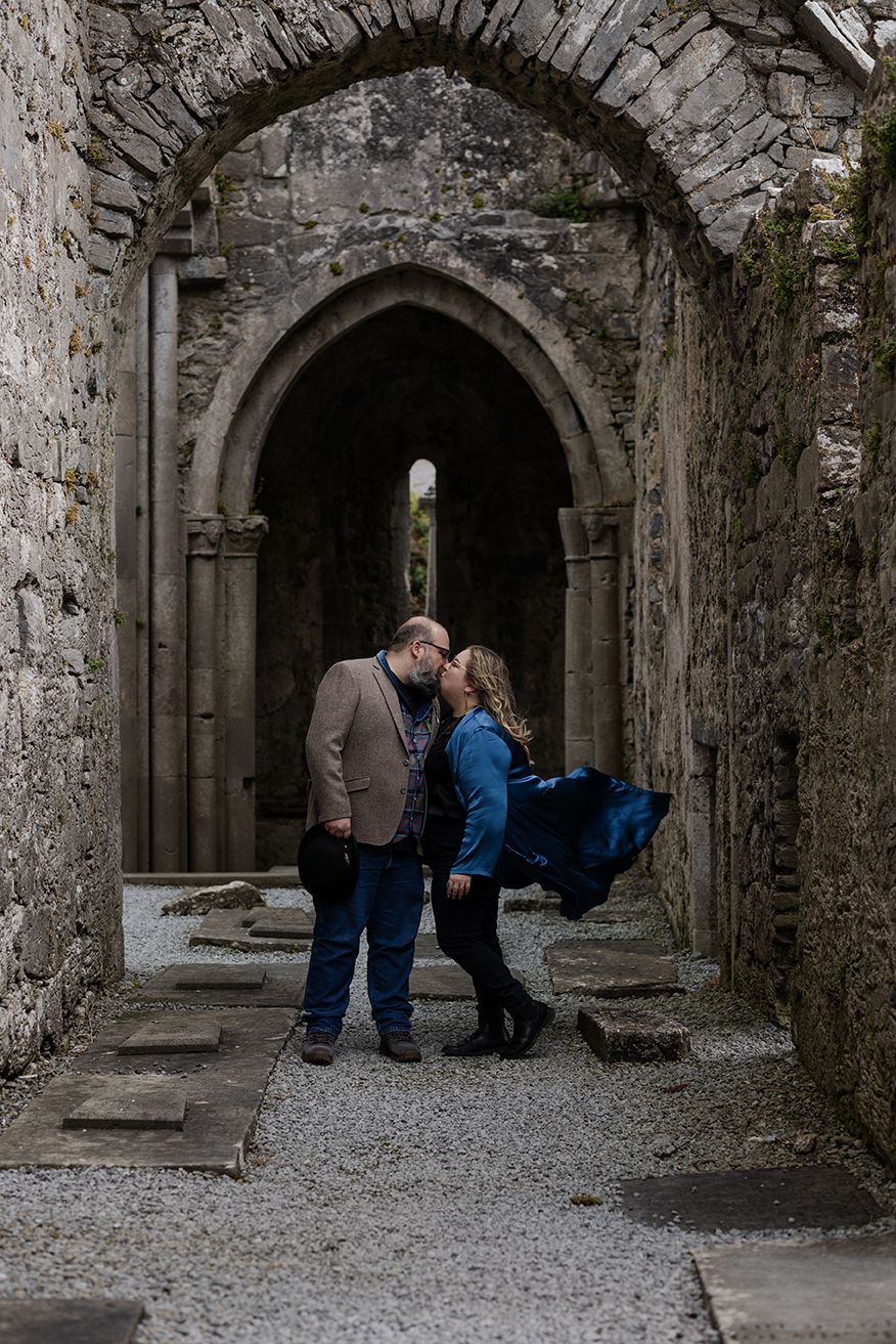 couple having intimate moment on a moody day at the Corcomroe Abbey during their adventure trip to Ireland