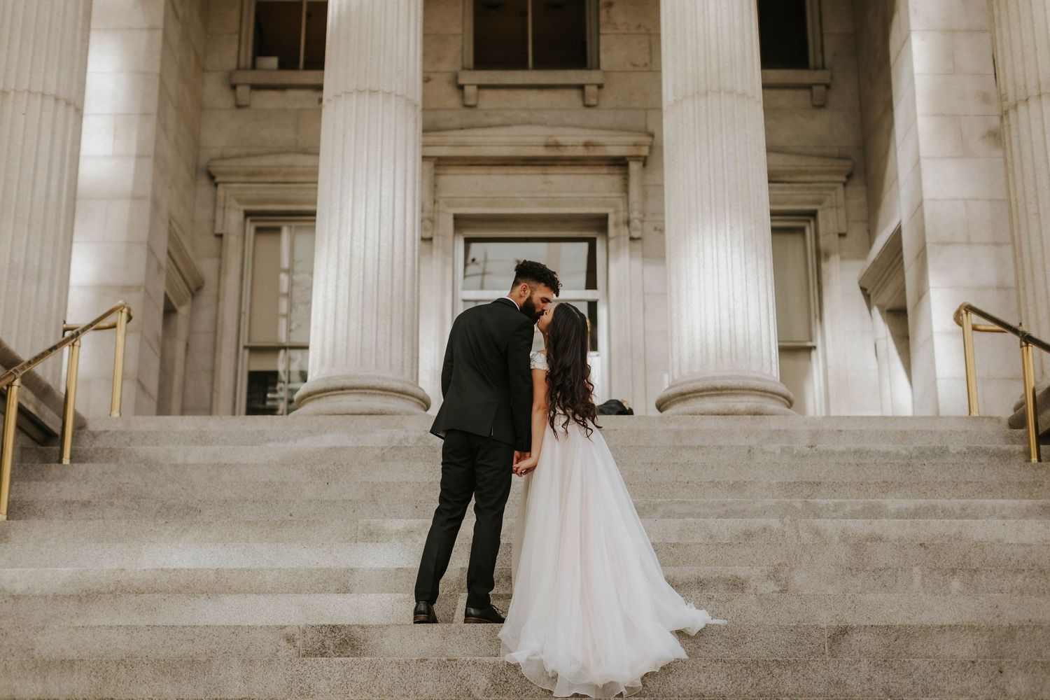 A grand white columned building entrance with stone steps and classical architecture.