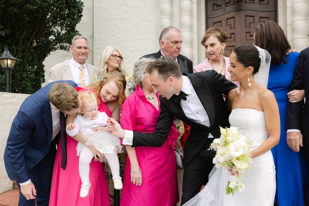Wedding party sharing a candid moment together outdoors while celebrating at a formal ceremony.