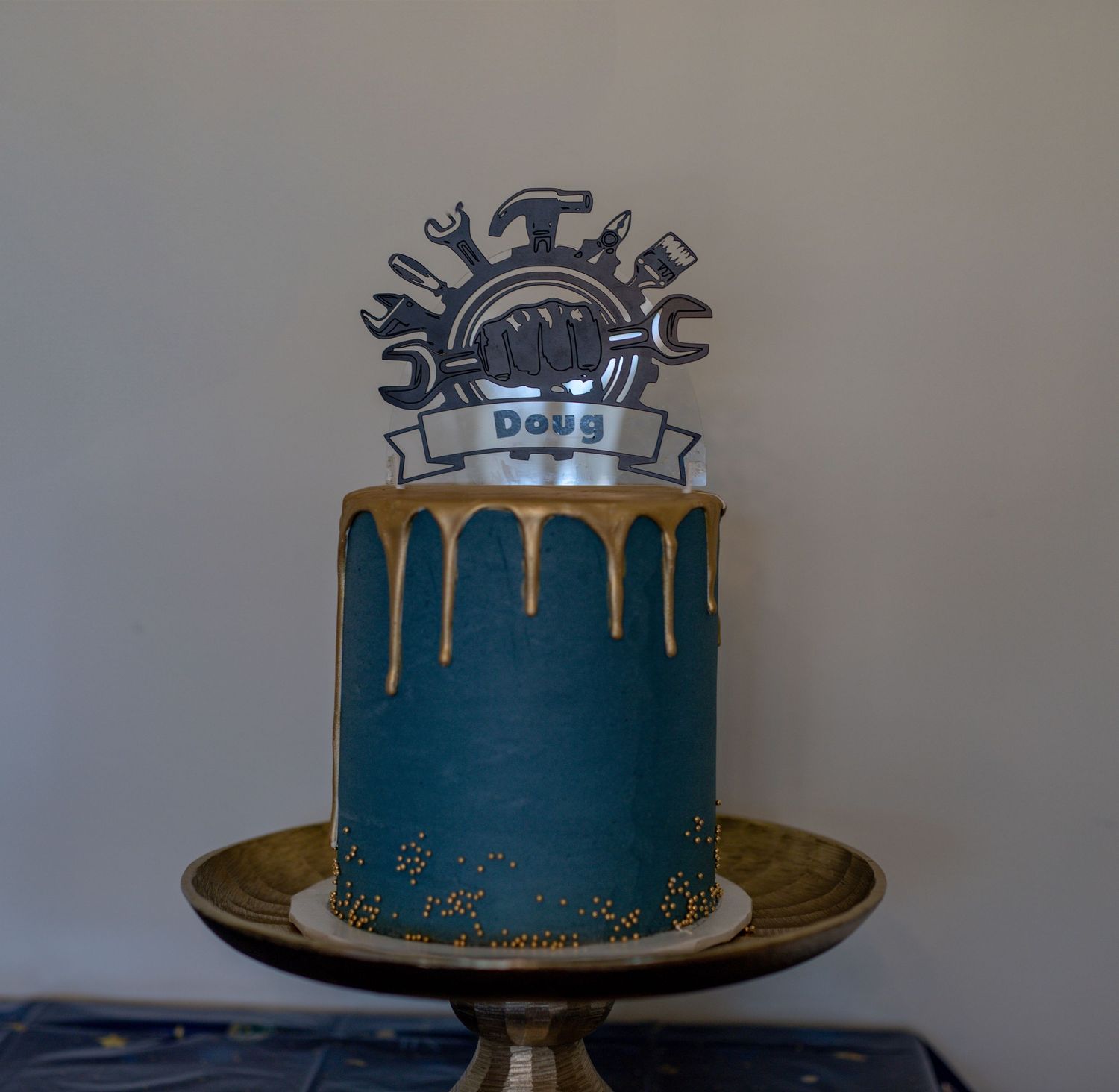 Teal birthday cake with gold drip effect and vintage car topper decoration.