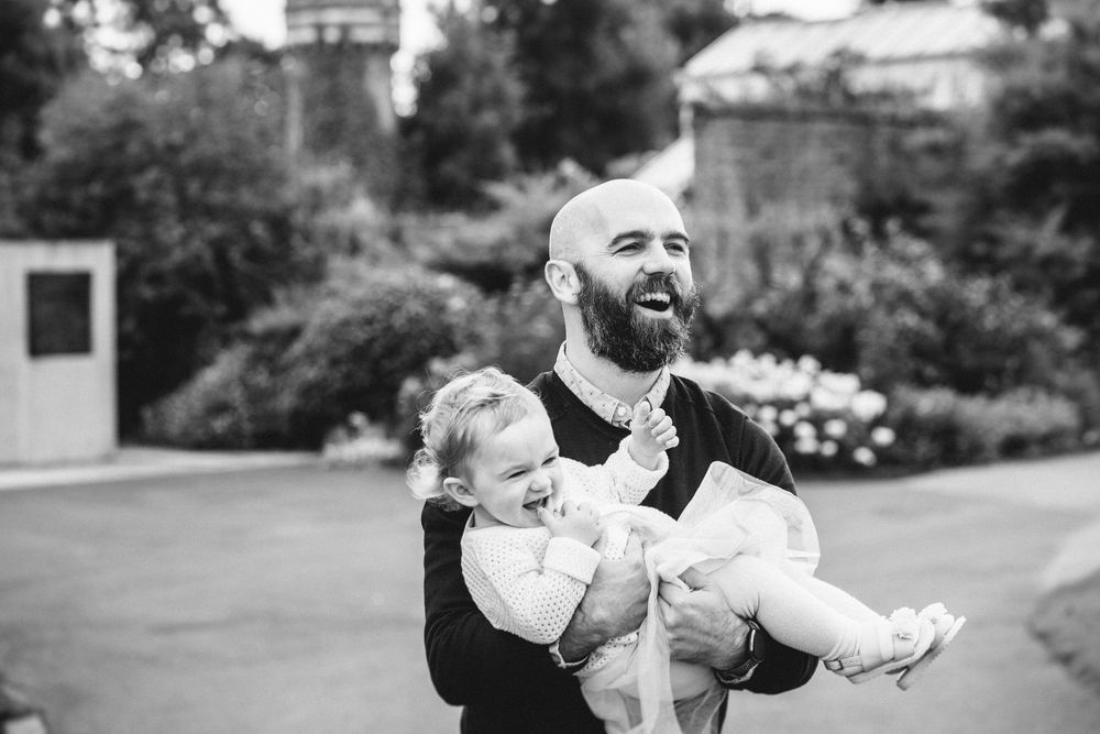 A black and white photo series showing tender moments between a parent and baby across multiple frames.