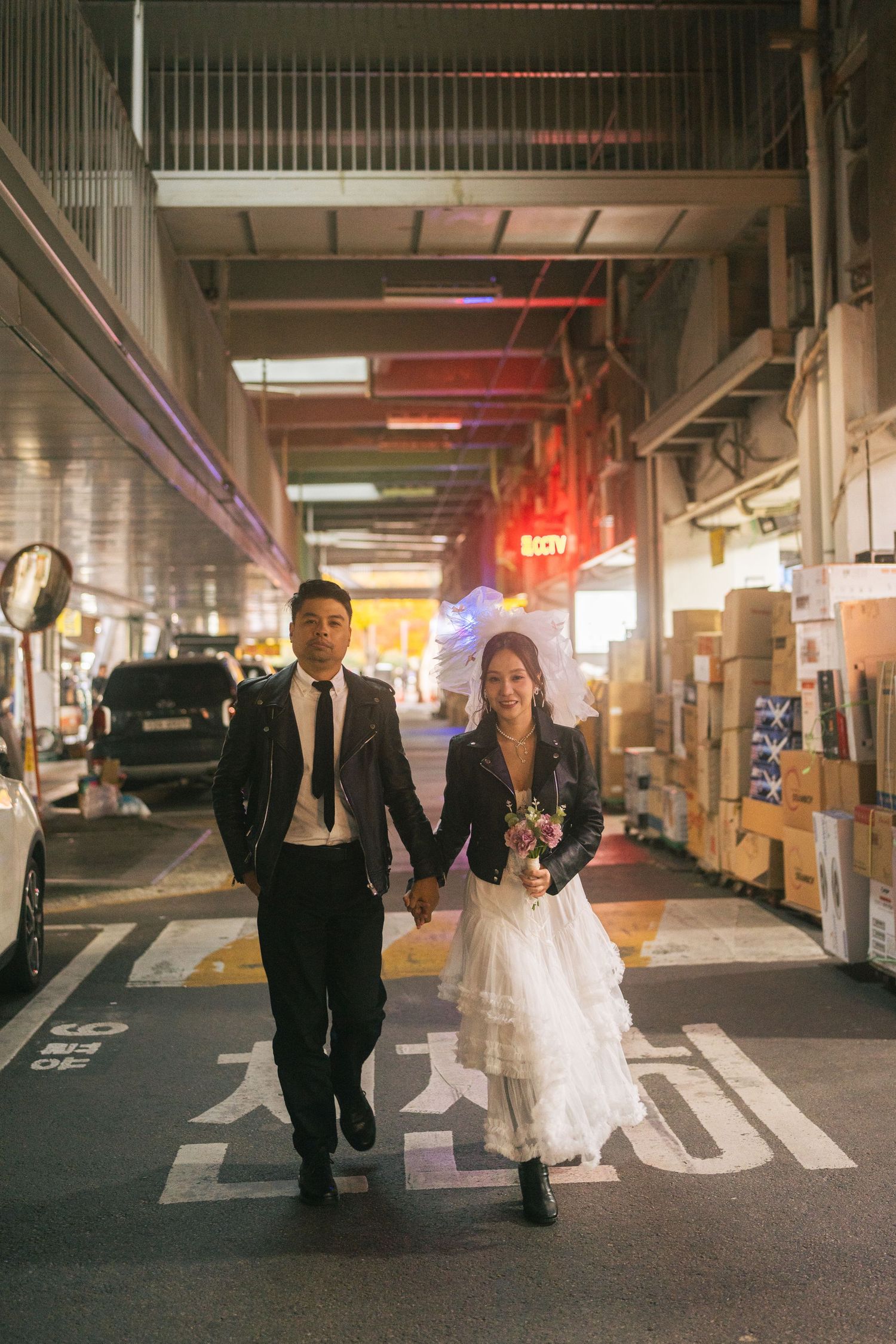 Wedding couple walks together through an illuminated parking garage in a creative photo sequence.