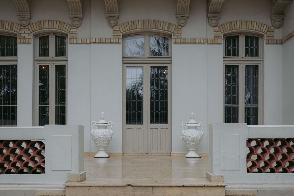 Ornate architectural details on a historic building facade with white columns and decorative window moldings.