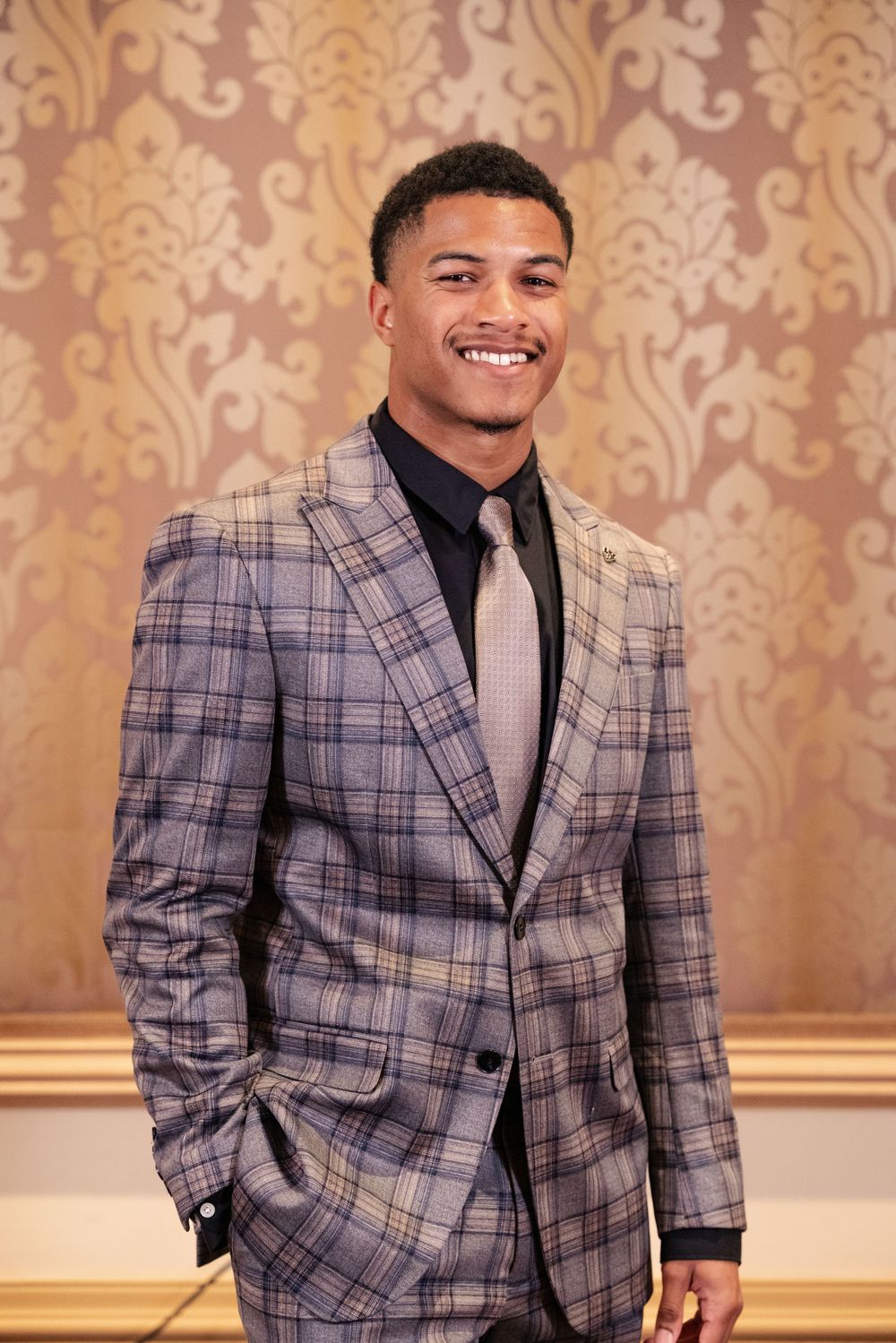 Professional portrait series showing a person in a stylish gray plaid blazer against an ornate gold wallpaper background.