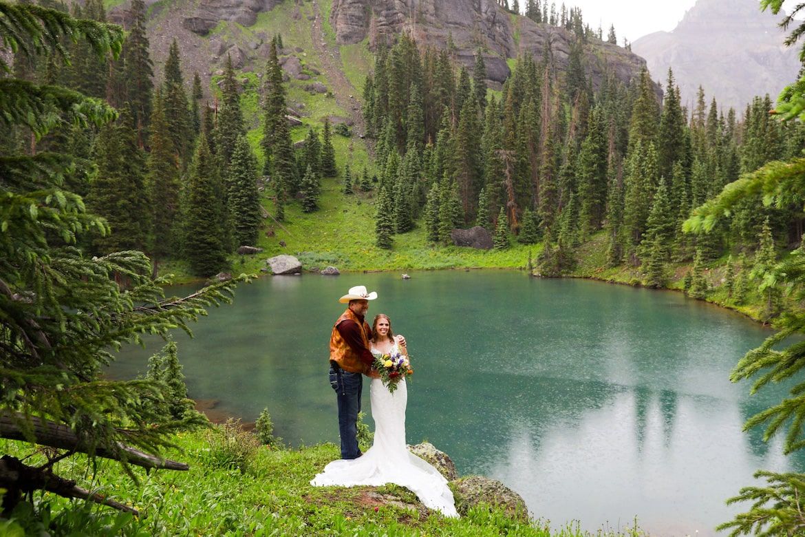 Scenic mountain lake surrounded by evergreen forests and alpine meadows with turquoise water reflecting the landscape.