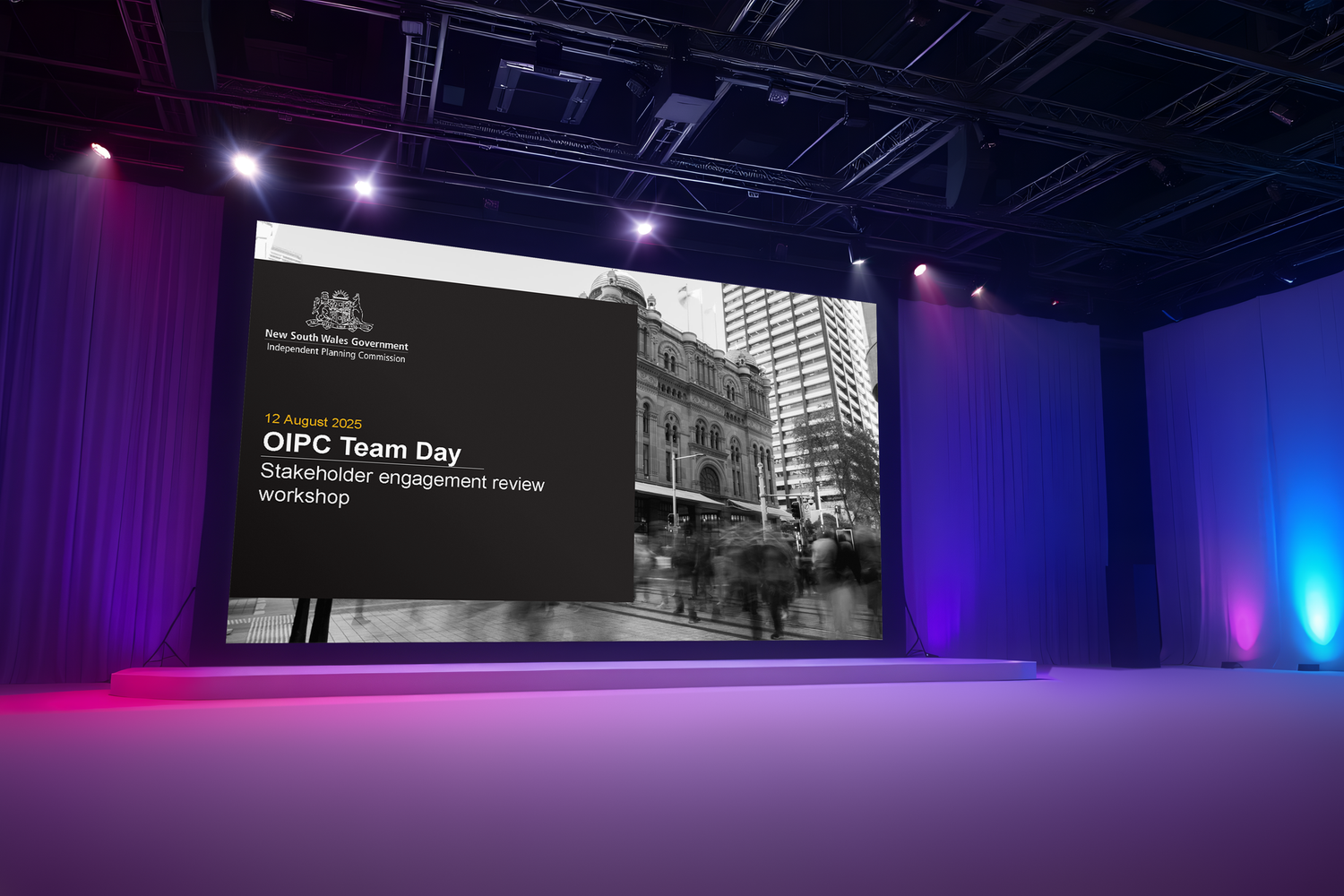 Empty stage with dramatic purple and blue lighting illuminating a large presentation screen in a modern conference venue.