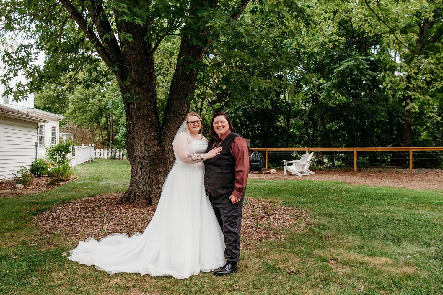 Wedding couple embracing in front of a white garden gazebo during an outdoor ceremony at the Appalachian Wedding Chapel.