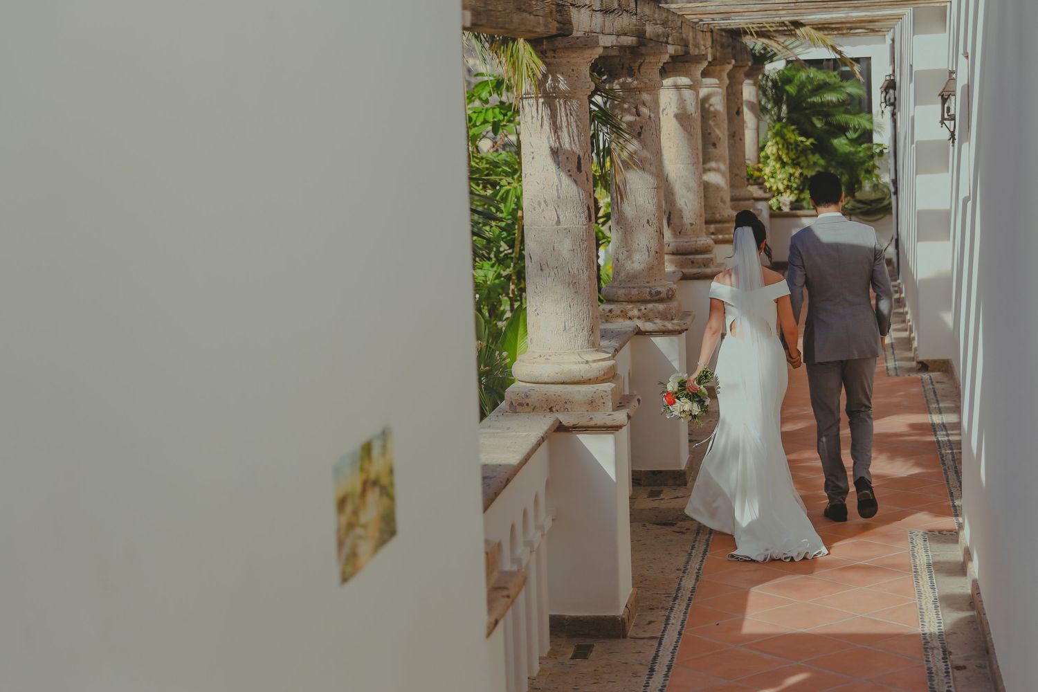 Wooden deck with chairs and tables arranged in a row along a covered outdoor patio area.Pedregal Los Cabos Wedding Photographer