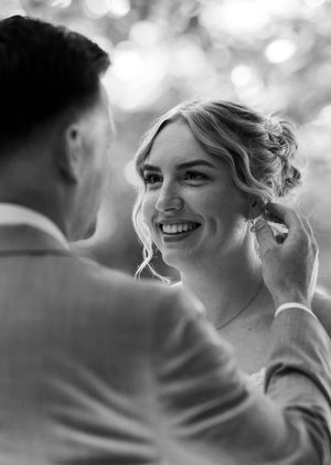 Black and white candid wedding moment with soft bokeh lighting effects.