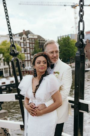 Couple shares intimate moment by waterfront chain railings.