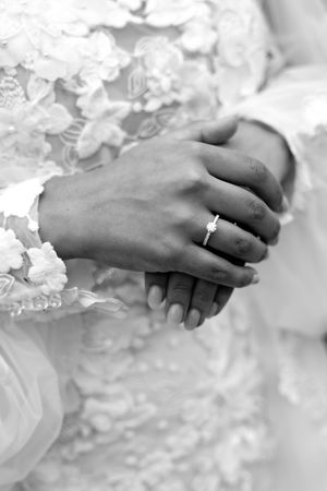 Close-up shots of hands with wedding rings against delicate white lace details.
