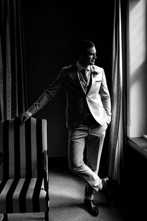 Dramatic black and white portraits showing elegant formal attire in window light.