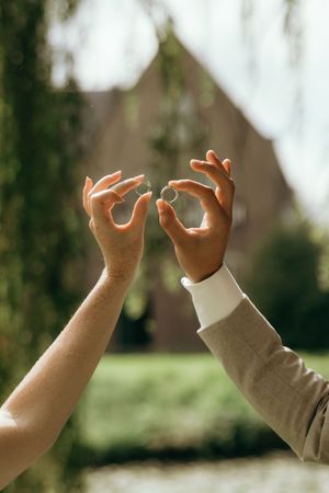 Artistic sequence of hands making heart shapes against a blurred outdoor background.