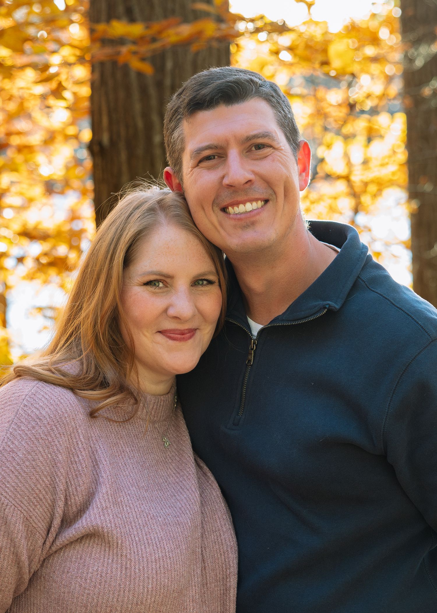 Smiling couple embracing in autumn woods — natural light family and couples photography