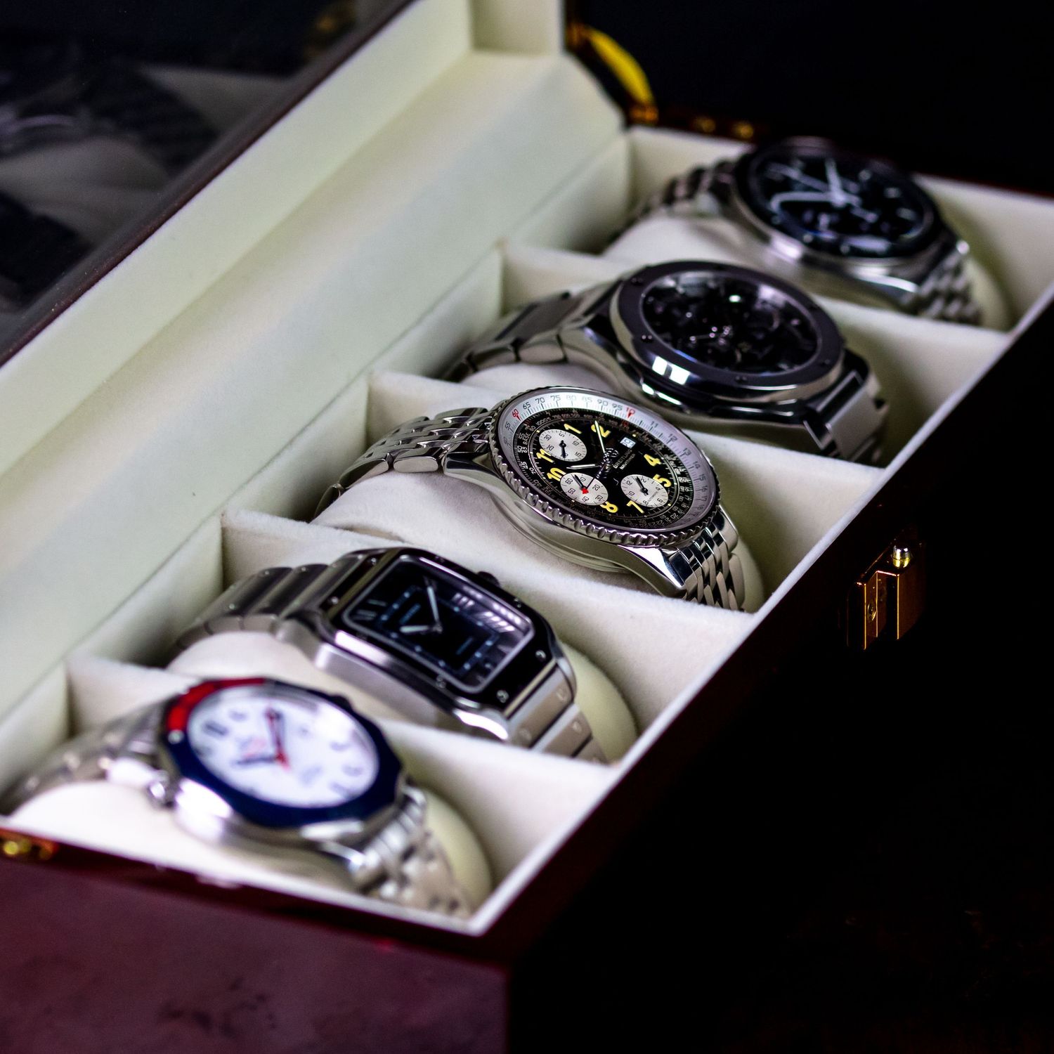 A collection of luxury watches displayed in white presentation boxes showing a progression from left to right.