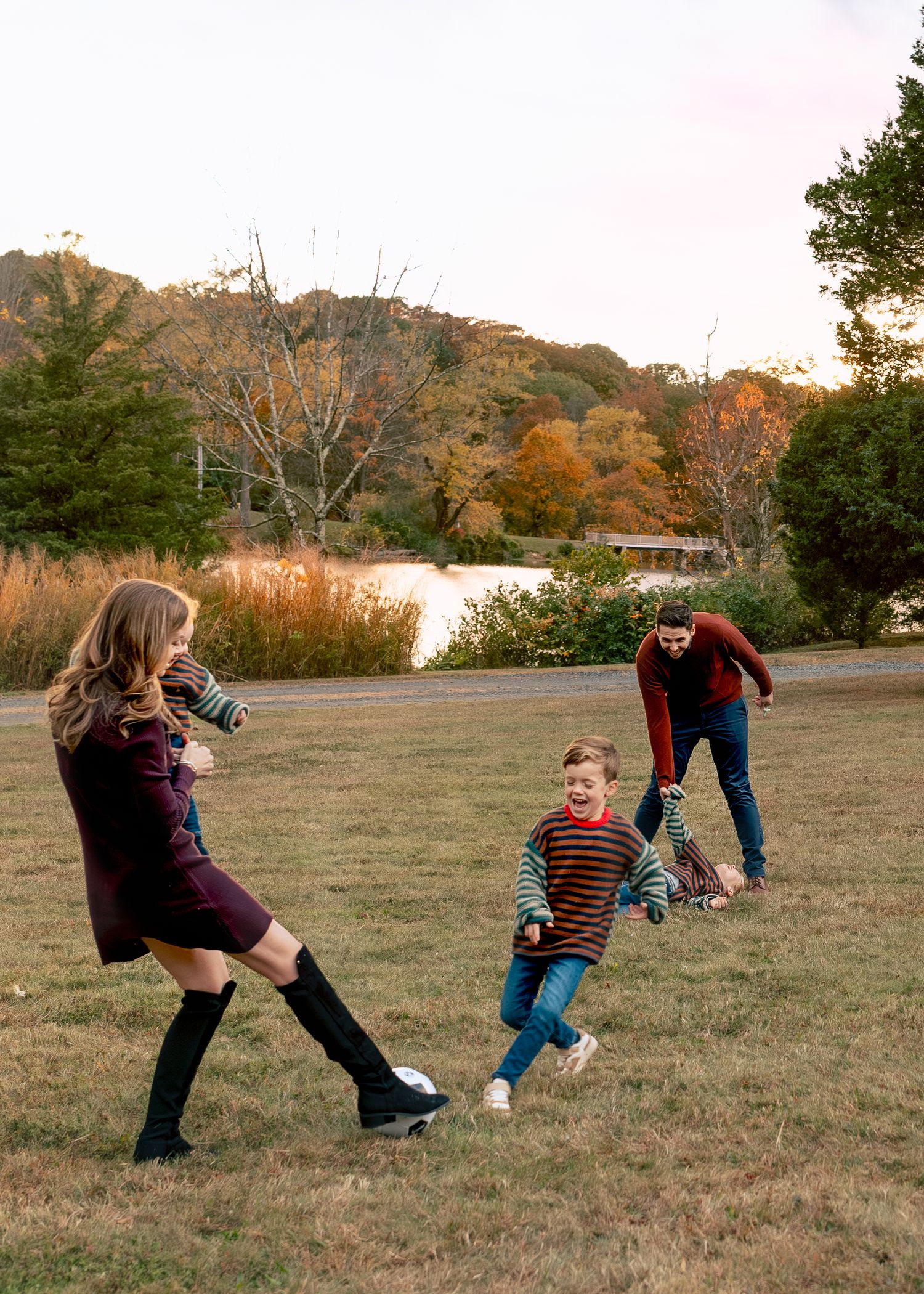 Action sequence of people playing soccer in a grassy field during autumn with trees in the background.