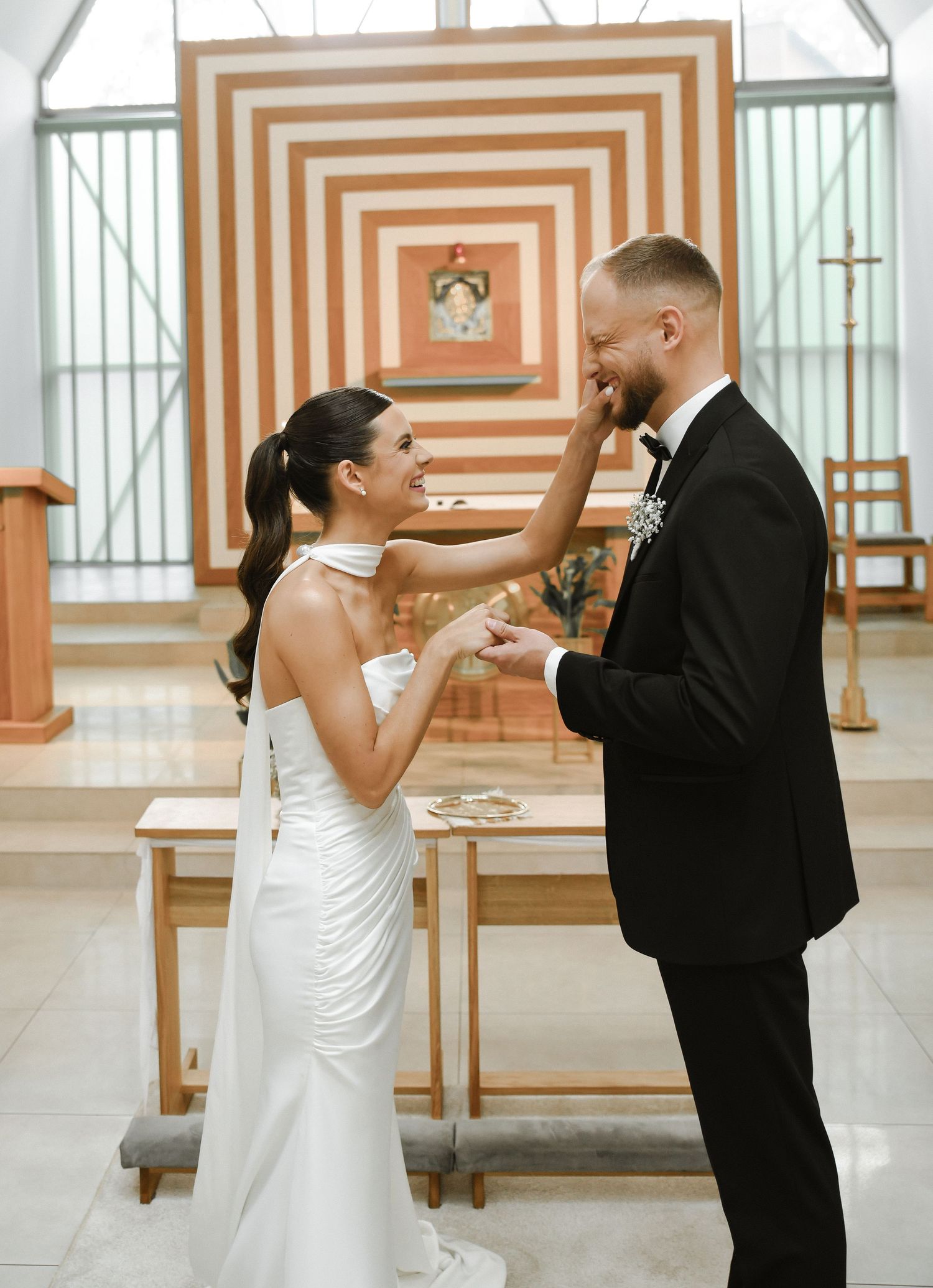A couple performs a choreographed first dance sequence in a bright reception hall with striped walls.