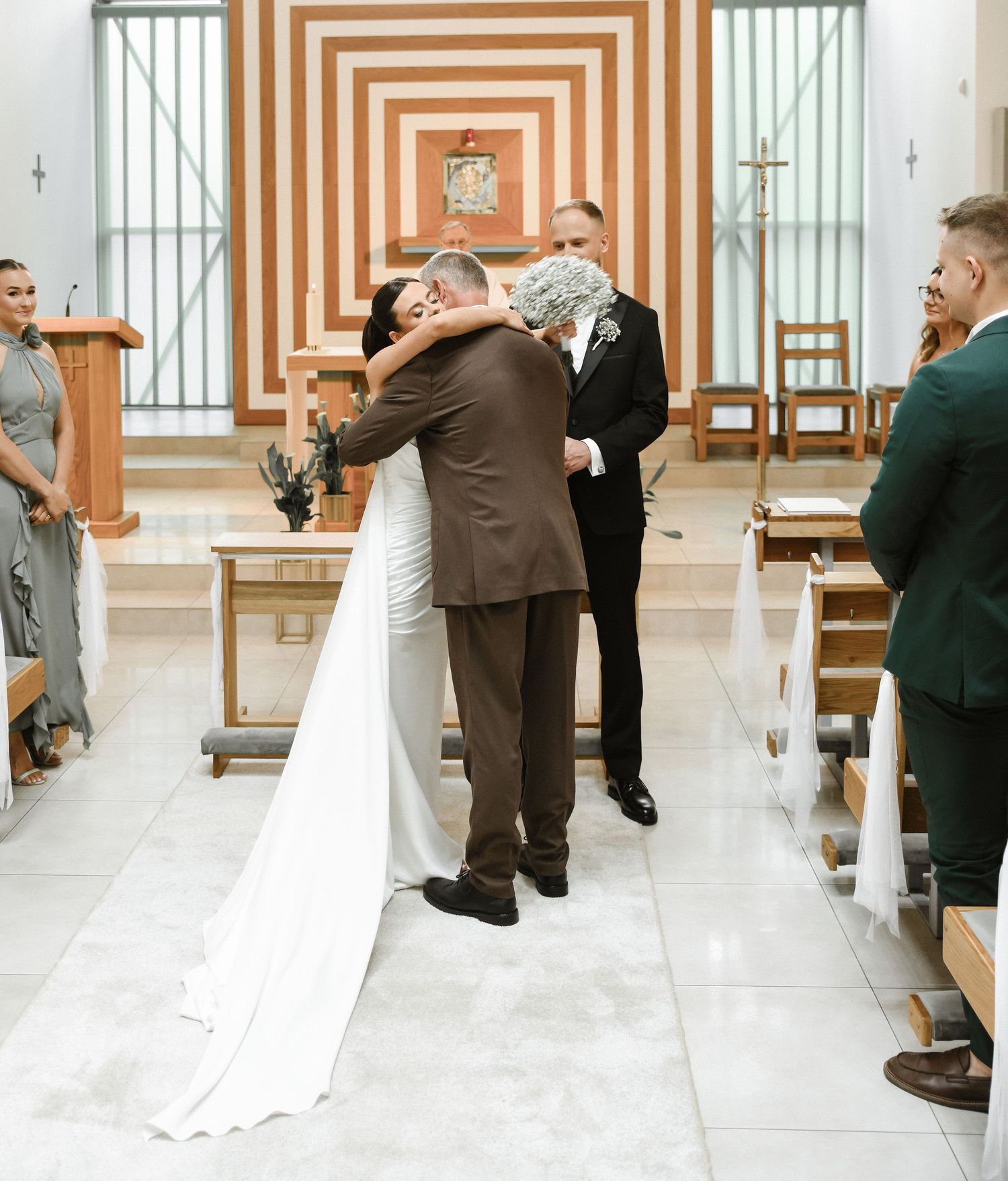 Elegant wedding ceremony in a church with white and orange striped walls and decorative details.