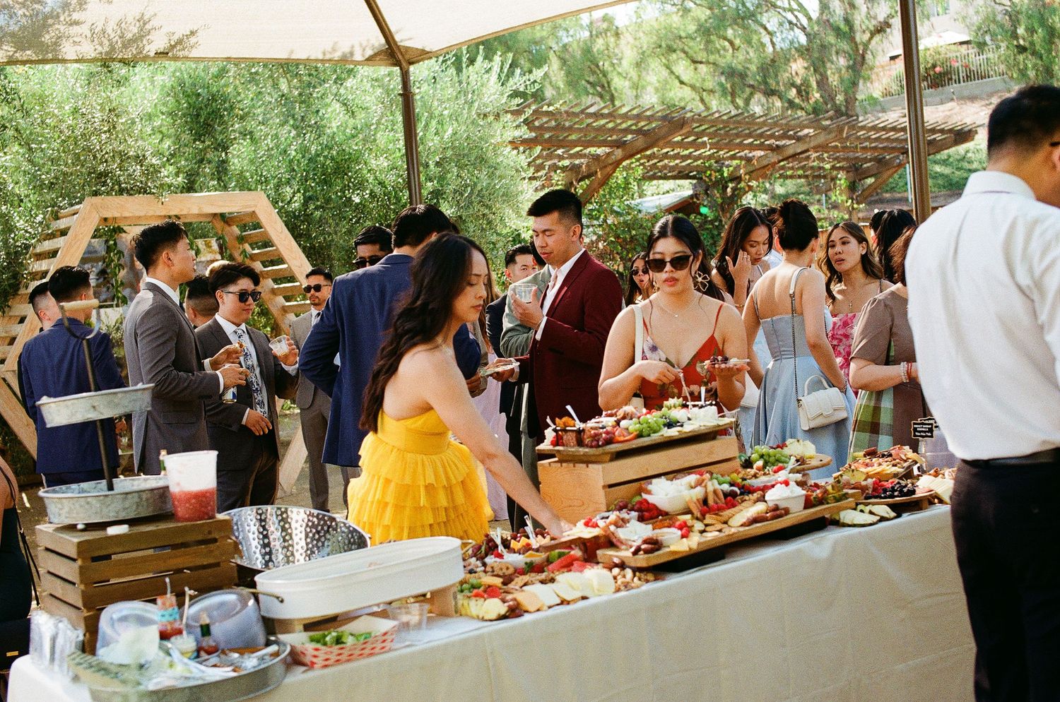 Candid film shot of guests enjoying dinner at an Orange County wedding, highlighting the casual reception atmosphere.