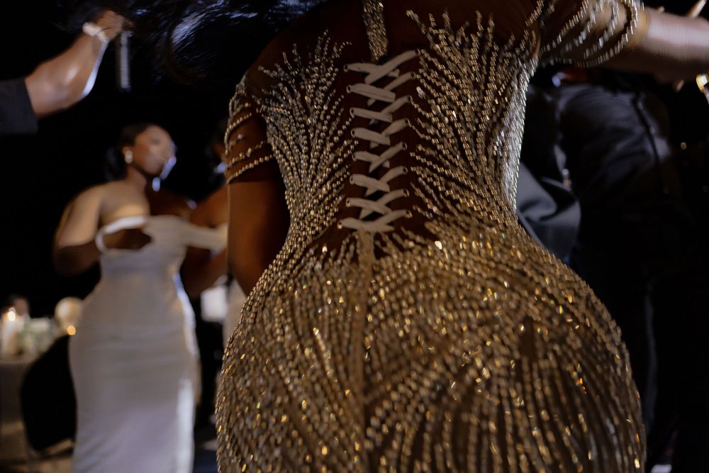 A person wearing a dramatic gold and black feathered headdress performs on stage during a theatrical production.