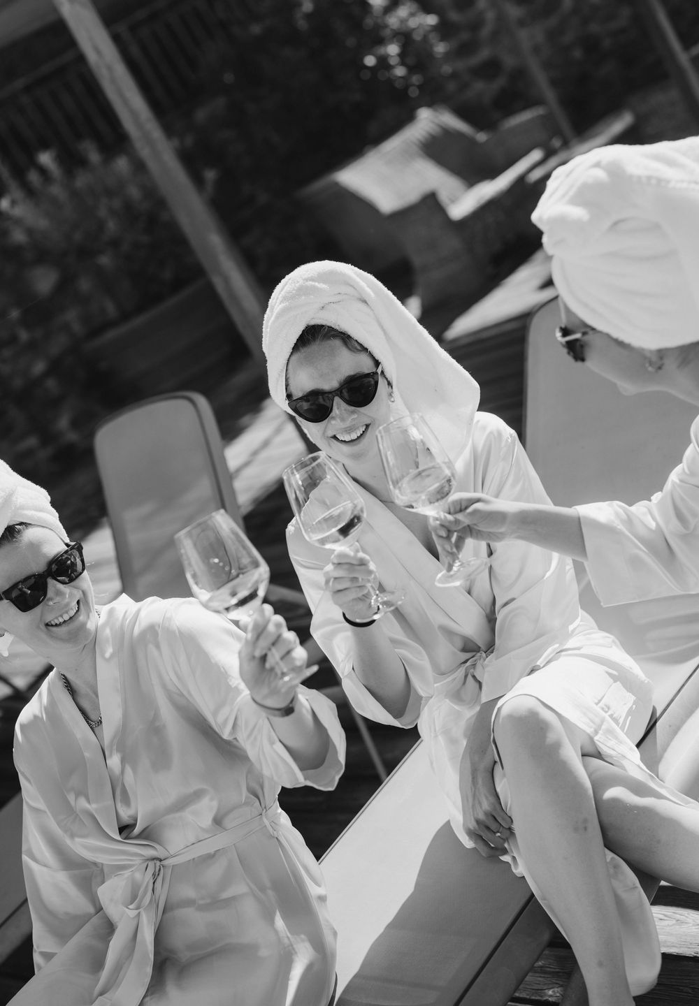 People in white robes and sunglasses lounging outdoors in black and white photography.