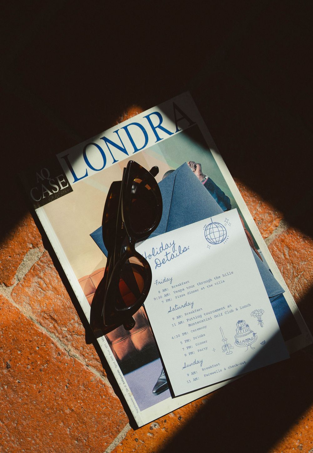 Wedding itinerary and schedule cards photographed in dramatic lighting on terracotta surface.